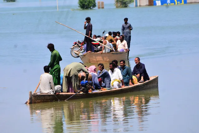 People are carried by boat after flash flood hits Kahirpur district in southern Sindh province, Pakistan, on September 04, 2022. Death toll of the devastating flood across Pakistan reaches more than 1,200 people, injured more than 6,000 people and affected, some 33 million people since June 14. (Photo by Ahmed Ali/Anadolu Agency via Getty Images)