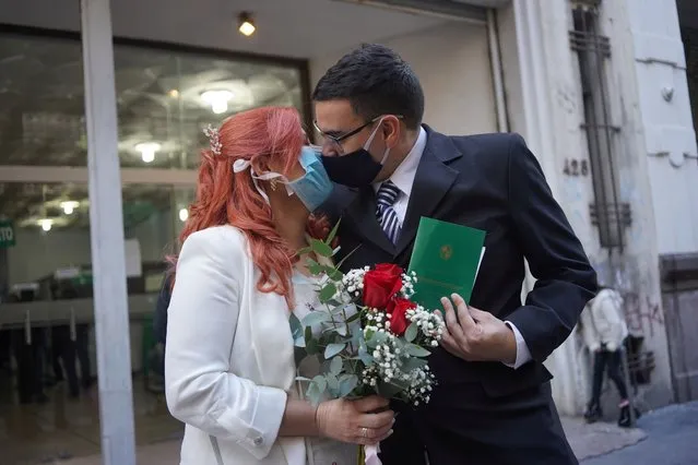 Newlyweds Laura Gomez (L) and Martin Larzabal kiss while wearing face masks after getting married at a civil status registration office amid the outbreak of the coronavirus disease (COVID-19), in Montevideo, Uruguay on May 8, 2020. (Photo by Mariana Greif/Reuters)
