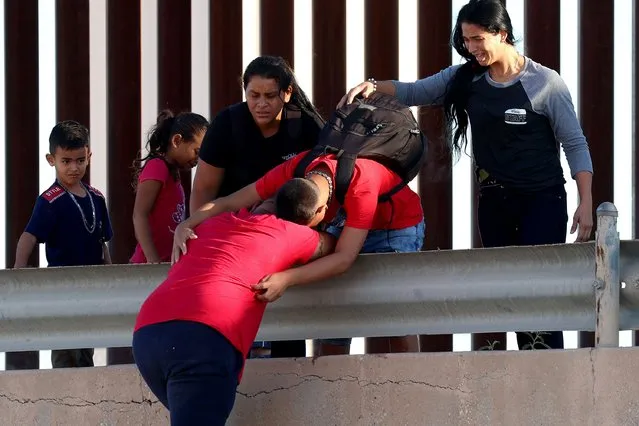 Venezuelan migrants hug as they reach the U.S. border fence to turn themselves in to the U.S. Border Patrol after crossing the Rio Grande from Mexico on September 22, 2022 in El Paso, Texas. In recent weeks, Venezuelans have arrived in increasing numbers in El Paso. The city has had to scramble to find housing and other aid for the migrants. (Photo by Joe Raedle/Getty Images)