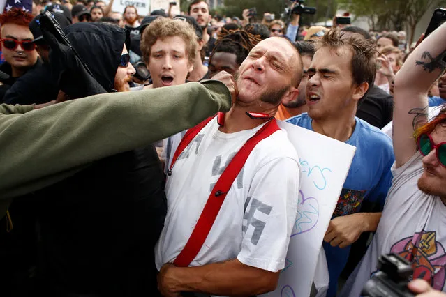 A man wearing a shirt with swastikas on it is punched by an unidentified member of the crowd near the site of a planned speech by white nationalist Richard Spencer, who popularized the term “alt-right”, at the University of Florida campus on October 19, 2017 in Gainesville, Florida. A state of emergency was declared on Monday by Florida Gov. Rick Scott to allow for increased law enforcement due to fears of violence. (Photo by Brian Blanco/Getty Images)
