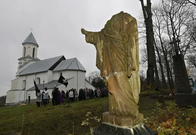 Belarus Catholics take part in a procession marking All Saints' Day at a cemetery in the village of Vselyub, 150 km (93 miles) west of Minsk, Wednesday, November 1, 2017. Belarusian Catholics marked All Saints Day by visiting graves of their relatives. (Photo by Sergei Grits/AP Photo)