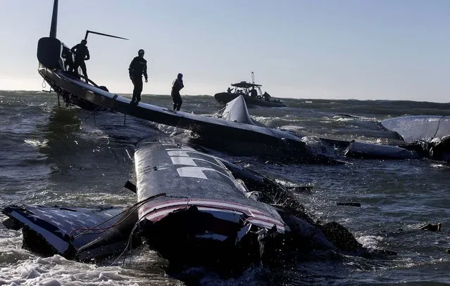 Crew members of the capsized Oracle Team USA AC72 boat are rescued after being swept past the Golden Gate Bridge in San Francisco. (Photo by Guilain Grenier/Oracle Team USA)