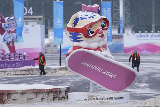 Workers try to clear an area with snow ahead of the 9th Asian Winter Games in Harbin, China on Friday, February 7, 2025. (Photo by Aaron Favila/AP Photo)