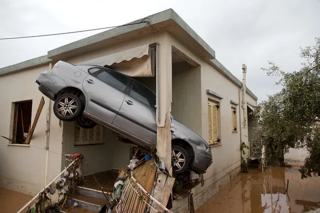 A car at the entrance of a flooded house after the water has receded in the town of Mandra western Athens, on Thursday, November 16, 2017. Greece's fire department says rescue crews are searching for six people reported missing in the western Athens area following major flash flooding that left at least 14 people dead. (Photo by Petros Giannakouris/AP Photo)