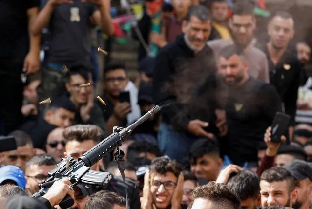 A gunman fires a weapon in the air as mourners attend the funeral of member of Palestinian group Lions' Den Wadee Al-Houh, who was killed during clashes with Israeli force, in Nablus in the Israeli-occupied West Bank on October 25, 2022. (Photo by Raneen Sawafta/Reuters)