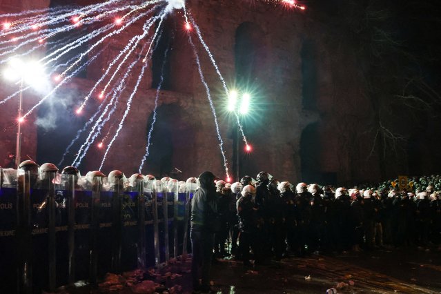 A firework explodes near police officers during a protest on the day Istanbul Mayor Ekrem Imamoglu was jailed as part of a corruption investigation, in Istanbul, Turkey, on March 23, 2025. (Photo by Dilara Senkaya/Reuters)
