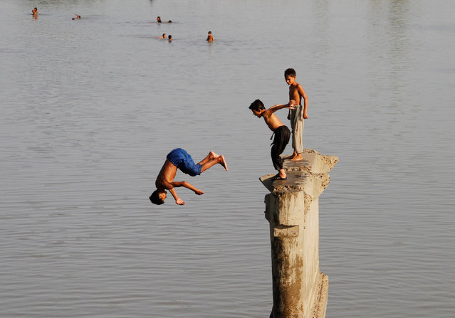 Children play as they jump is the Sardaryab River at Charsadda, on the outskirts of Peshawar, Pakistan, August 22, 2016. (Photo by Fayaz Aziz/Reuters)