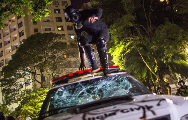 A protester in favor of former President Dilma Rousseff jumps on a police vehicle during a protest march on August 31, 2016 in Sao Paulo, Brazil. Rousseff was impeached in a 61-to-20 Senate vote earlier in the day. (Photo by Victor Moriyama/Getty Images)
