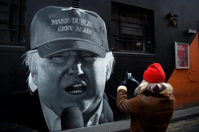 A woman takes a picture of a mural of Donald Trump in Dublin, Ireland, December 1, 2017. (Photo by Clodagh Kilcoyne/Reuters)