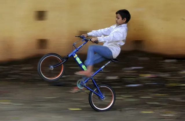 A boy does a wheelie on a bicycle at a municipal playground in Bengaluru, India, September 8, 2015. (Photo by Abhishek N. Chinnappa/Reuters)