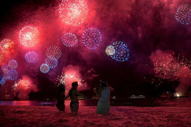 People watch as fireworks explode over Copacabana beach in Rio de Janeiro, Brazil on January 1, 2018. (Photo by Lucas Landau/Reuters)