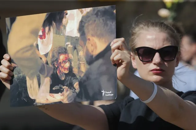 A woman holds a photo of a protester, beaten by police during a rally in Minsk, Belarus, Saturday, August 15, 2020. Thousands of demonstrators have gathered at the spot in Belarus' capital where a protester died in clashes with police, calling for authoritarian President Alexander Lukashenko to resign. (Photo by Dmitri Lovetsky/AP Photo)