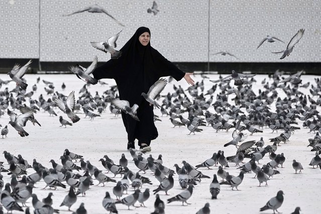 A Muslim pilgrim plays with pigeons outside the Grand Mosque during the annual hajj pilgrimage in Mecca, Saudi Arabia, Tuesday, June 3, 2025. (Photo by Amr Nabil/AP Photo)