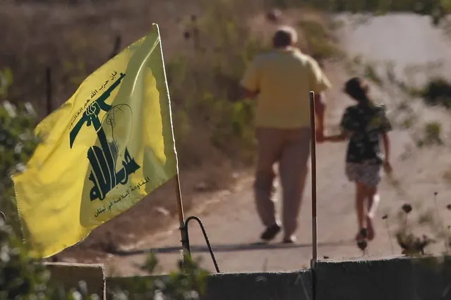 A Hezbollah flag hangs on a concrete barrier in southern Lebanon on the border with Israel, Wednesday, August 26, 2020. Israeli attack helicopters struck observation posts of the militant Hezbollah group along the Lebanon border overnight after shots were fired at Israeli troops operating in the area, the military said Wednesday. (Photo by Ariel Schalit/AP Photo)