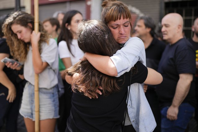Telam workers hug outside the state-run Telam news agency in Buenos Aires, Argentina, Monday, March 4, 2024. Télam was inactive on Monday and its employees were laid off and unable to enter the facility after President Javier Milei announced its closure on March 1. (Photo by Natacha Pisarenko/AP Photo)