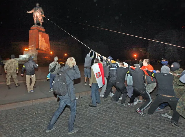 Participants of the rally “Kharkov is Ukraine” demolish the monument to Vladimir Lenin in the Constitution Square, Kharkiv, Ukraine on September 29, 2014. (Photo by Sergey Kozlov/TASS)
