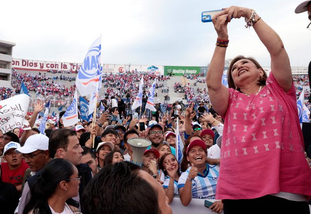 Mexico's opposition presidential candidate, Xóchitl Gálvez of the Fuerza y Corazón por México coalition party, takes a selfie with supporters at a campaign kick-off rally in Irapuato, Guanajuato State, Mexico, on March 1, 2024. Campaigning officially began Friday for elections likely to produce Mexico's first woman president – a watershed for a nation with a long tradition of macho culture. Opposition candidate Xochitl Galvez launched her campaign after the stroke of midnight in one of Mexico's most dangerous states, seeking to tap into voter concerns about the country's rampant violence. (Photo by Ulises Ruiz/AFP Photo)