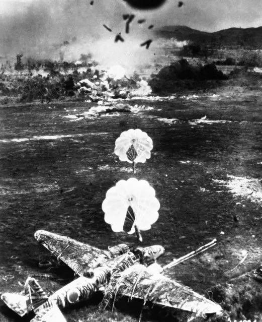 Two Parafrag bombs head towards a carefully camouflaged Japanese Sally plane during an attack by the US Army Fifth Air Force against Old Namlea airport on Buru Island, Dutch East Indies, on October 15, 1944. A few seconds after this picture was taken the aircraft was engulfed in flames. The design of the Parafrag bomb enables low flying bombing attacks to be carried out with pin-point accuracy. (Photo by AP Photo)