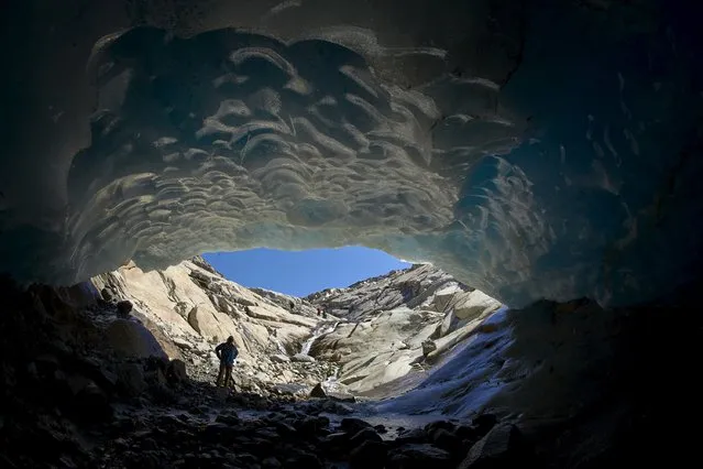 Mountain guide Christian Pletscher stands in a cave on the Aletsch Glacier in Fiesch, Switzerland, August 29, 2015. (Photo by Denis Balibouse/Reuters)