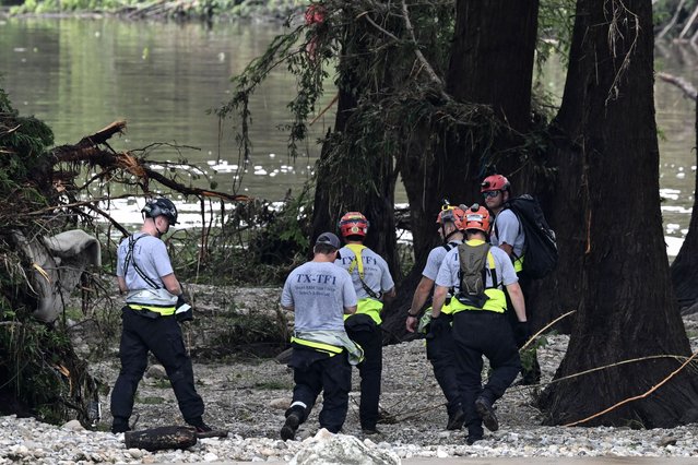 Members of a search and rescue team look for people near Camp Mystic, the site of where at least 20 girls went missing after flash flooding in Hunt, Texas, on July 5, 2025. Rescuers were on Saturday searching for more than 20 girls missing from a riverside summer camp in the US state of Texas, after torrential rains caused devastating flooding that killed at least 27 people -- with more rain on the way. “So far, we've evacuated over 850 uninjured people, eight injured people and have recovered 27 deceased fatalities at this time. Of these 27, 18 are adults, nine are children”, said Kerr Country Sheriff Larry Leitha on July 5. (Photo by Ronaldo Schemidt/AFP Photo)
