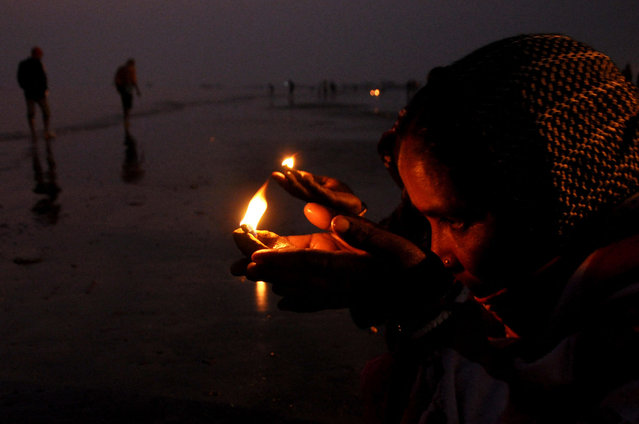 Hindu pilgrims perform rituals after taking a dip at the confluence of Ganges and the Bay of Bengal during the Gangasagar Mela on the occasion of Makar Sankranti, a day considered to be of great religious significance in Hindu mythology, at Sagar Island, around 150 kms south of Kolkata on January 13, 2023. (Photo by AFP Photo)