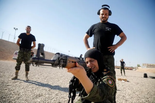 Amal Khalifa, a female colonel, fires a weapon at a target as she guides members of Palestinian security forces during a shooting practice, in Jericho in the Israeli-occupied West Bank on August 16, 2020. (Photo by Raneen Sawafta/Reuters)