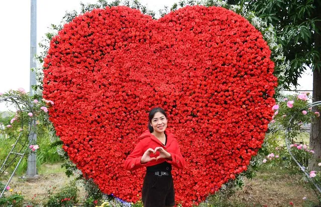 A woman poses for photos during the flower festival at Me Linh district in the suburb of Hanoi on December 9, 2022. (Photo by Nhac Nguyen/AFP Photo)