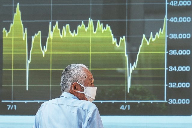 A person looks at an electronic stock board showing Japan's Nikkei index at a securities firm Tuesday, July 1, 2025, in Tokyo. (Photo by Eugene Hoshiko/AP Photo)