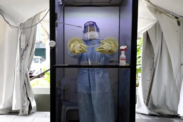 A doctor waits inside a protective chamber to takes a swab from a patient to test for the coronavirus disease (COVID-19) at Sunway Medical Centre, as the outbreak continues in Subang Jaya, Malaysia on October 8, 2020. (Photo by Lim Huey Teng/Reuters)