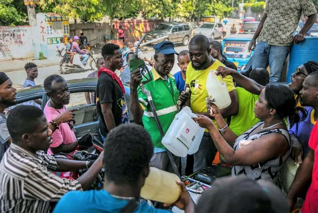 People crowd around a gas pump as they try to get their gas tanks filled, at a gas station in Port-au-Prince, Haiti, Saturday, November 12, 2022. (Photo by Joseph Odelyn/AP Photo)