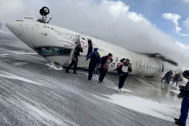 Passengers leave a Delta Air Lines CRJ-900 jet after it crashed on landing at Toronto Pearson International Airport in Mississauga, Ontario, Canada on February 17, 2025 in a still image from video. (Photo by Peter Koukov/Handout via Reuters)