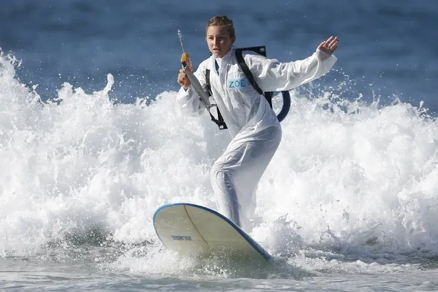 A competitor surfs dressed as a character from "Ghostbusters" during the ZJ Boarding House Haunted Heats Halloween Surf Contest in Santa Monica, California, United States, October 31, 2015. (Photo by Lucy Nicholson/Reuters)