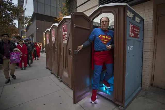 A man dressed as Superman walks out of portable bathroom before the Greenwich Village Halloween Parade in the Manhattan borough of New York, October 31, 2015. (Photo by Carlo Allegri/Reuters)