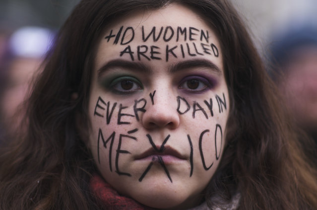 A woman from Mexico with a message draw in her face about the situation in her home country attends a rally marking International Women's Day 2023 in Berlin, Germany, Wednesday, March 8, 2023. (Photo by Markus Schreiber/AP Photo)