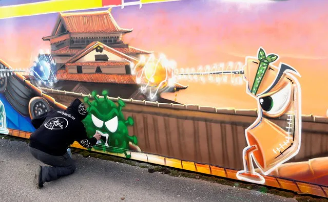 Artist David “S.I.D.” Perez paints a graffiti, representing two vaccines (Modernos 19 and Pizter Klorokinos) fighting against a virus in the background of a popular video game Street Fighter, during the coronavirus disease (COVID-19) outbreak in Gland, Switzerland, December 3, 2020. (Photo by Denis Balibouse/Reuters)