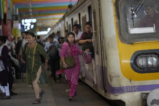 Women rush out of a train during peak hours at Churchgate station in Mumbai, India, Monday, March 20, 2023. 39 million women are employed in India's workforce compared to 361 million men, according to the Center for Monitoring the Indian Economy (CMIE). (Photo by Rajanish Kakade/AP Photo)