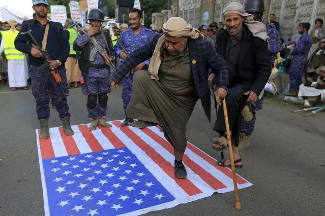 Yemenis step on a US flag during a demonstration on January 23, 2023 in the capital Sanaa, to condemn the burning of the Koran by a Swedish politician. Far-right Swedish politician Rasmus Paludan set fire to a copy of the Muslim holy book on January 21 in front of Turkey's embassy in the Swedish capital. (Photo by Mohammed Huwais/AFP Photo)