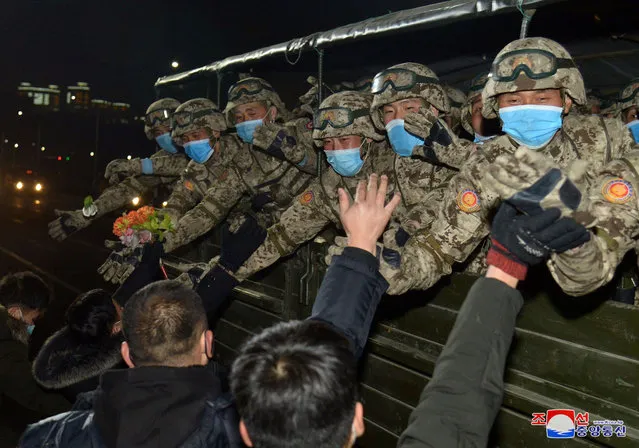 This picture taken on January 14, 2021 and released from North Korea's official Korean Central News Agency (KCNA) on January 15 shows North Korean soldiers greeting people during a military parade celebrating the 8th Congress of the Workers' Party of Korea (WPK) in Pyongyang. (Photo by KCNA via KNS/AFP Photo)
