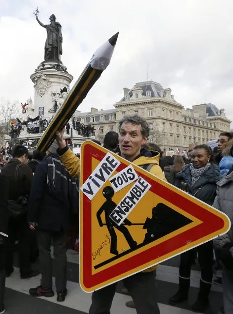 A Man carrying a rod sign reading “Live together” takes part in a Hundreds of thousands of French citizens solidarity march (Marche Republicaine) in the streets of Paris January 11, 2015. (Photo by Gonzalo Fuentes/Reuters)