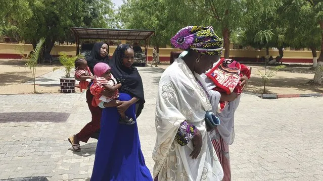 Recently freed Chibok schoolgirls are photographed with their children and government officials at the Army Maimalari Cantonment in Maiduguri, Nigeria, Thursday, May 4, 2023. Two Nigerian schoolgirls have been rescued after nine years in the capacity of a Jihadi militant group, the West African nation's military said Thursday. One girl had a baby while the second was pregnant and gave birth days after her freedom. (Photo by Jossy Ola/AP Photo)