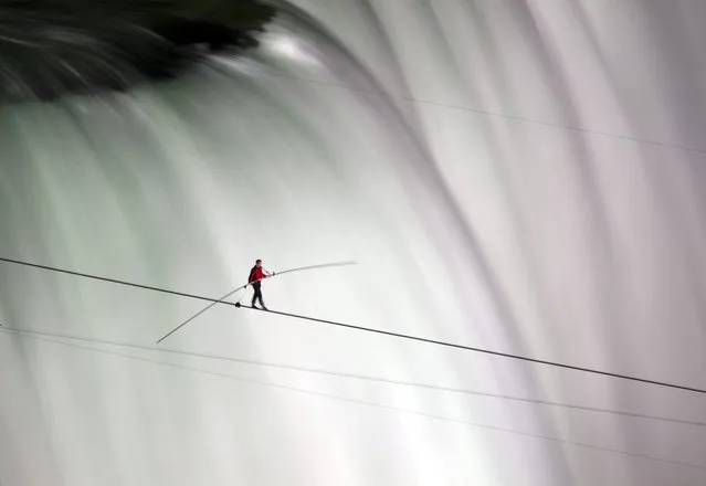 Nik Wallenda nears the middle of his tightrope walk over Niagara Falls as seen from Niagara Falls, Ontario, on Friday, June 15, 2012. Wallenda has finished his attempt to become the first person to walk on a tightrope 1,800 feet across the mist-fogged brink of roaring Niagara Falls. The seventh-generation member of the famed Flying Wallendas had long dreamed of pulling off the stunt, never before attempted. (Photo by Aaron Vincent Elkaim/AP Photo/The Canadian Press)