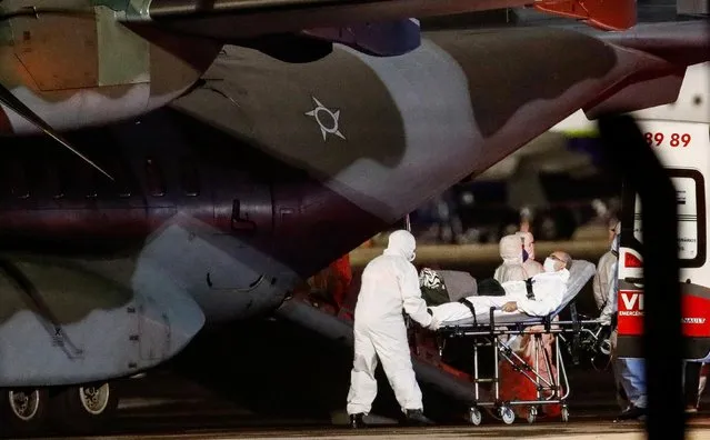 Health workers transport a COVID-19 patient from a Brazilian Air Force airplane after arriving from Porto Velho, Rondonia state, amid the coronavirus disease (COVID-19) outbreak, at Salgado Filho international airport in Porto Alegre, Brazil, January 27, 2021. (Photo by Diego Vara/Reuters)