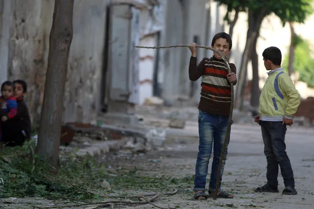 A boy breaks a branch to be used as firewood in a rebel-held besieged area in Aleppo, Syria November 6, 2016. (Photo by Abdalrhman Ismail/Reuters)