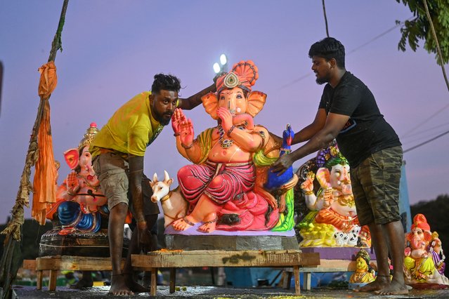 Devotees carry an idol of Hindu deity Ganesha for immersion into the Ulsoor Lake during the “Ganesh Chaturthi” festival in Bengaluru, India on September 13, 2024. (Photo by Idrees Mohammed/AFP Photo)