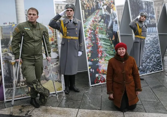 A woman cries as she kneels during a funeral ceremony for Georgian Tomaz Sukhiashvili, 35, a member of self-defence battalion “Donbass”, who was killed in the fighting in eastern Ukraine, at the Independence Square in central Kiev January 21, 2015. (Photo by Gleb Garanich/Reuters)