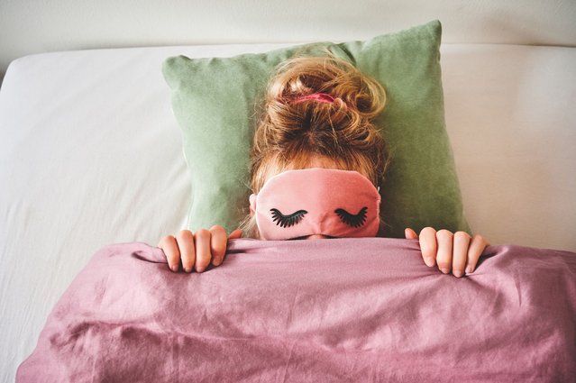 Cropped shot of an unrecongizable woman lying in bed with a sleep mask on and covering her face with her duvet. (Photo by Charday Penn/Getty Images)