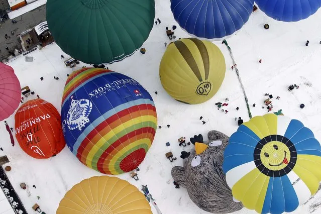 Balloons of all shapes and sizes get ready for take off at the 37th International Hot Air Balloon Week in Chateau-d'Oex, January 24, 2015. (Photo by Pierre Albouy/Reuters)