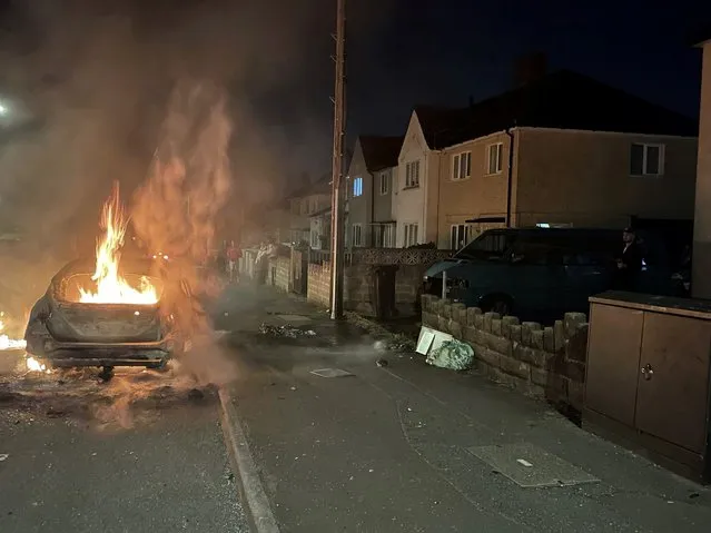 A car burns after being set on fire, on Highmead Road, Ely, in Cardiff, after a crash following a serious road traffic collision on Snowden Road in Ely in Cardiff, Tuesday, May 23, 2023. A few cars were set ablaze and objects were hurled at police after a traffic accident Monday night in the Welsh capital Cardiff grew into what officials described as “large scale disorder”. (Photo by Bronwen Weatherby/PA Wire via AP Photo)