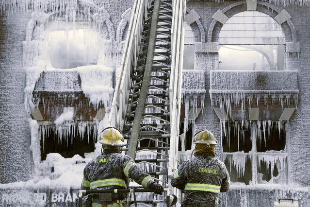 Philadelphia firefighters work the scene of an overnight blaze in west Philadelphia, Monday February 16, 2015, as icicles hang from where the water from their hoses froze. Bone-chilling, single digit temperatures have gripped the region, prompting the closure of all parish and regional Catholic elementary schools in the city of Philadelphia. (Photo by Jacqueline Larma/AP Photo)