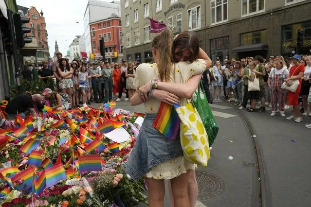 Two women embrace each other as they lay flowers at the scene of a shooting in central Oslo, Norway, Saturday, June 25, 2022. A gunman opened fire in Oslo’s night-life district early Saturday, killing two people and leaving more than 20 wounded in what Norwegian security service called an “Islamist terror act” during the capital’s annual Pride festival. (Photo by Sergei Grits/AP Photo)